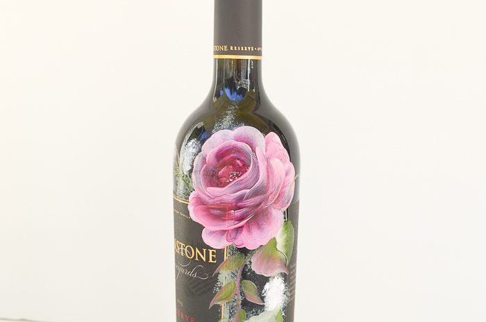 Pink roses painted on wine bottle.