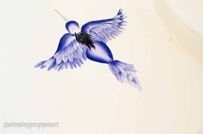 Add black feathers to shoulders and back of flying blue bird