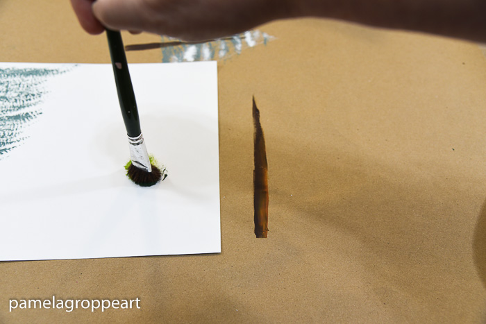 using a scruffy brush with green paint