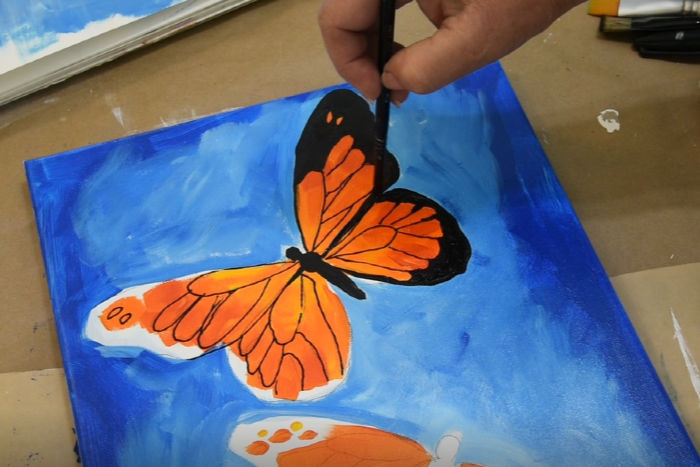 Paint outer edge of monarch butterfly wing with black paint