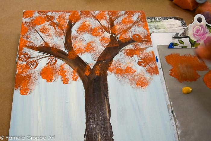 sponging terra cotta color paint onto tree