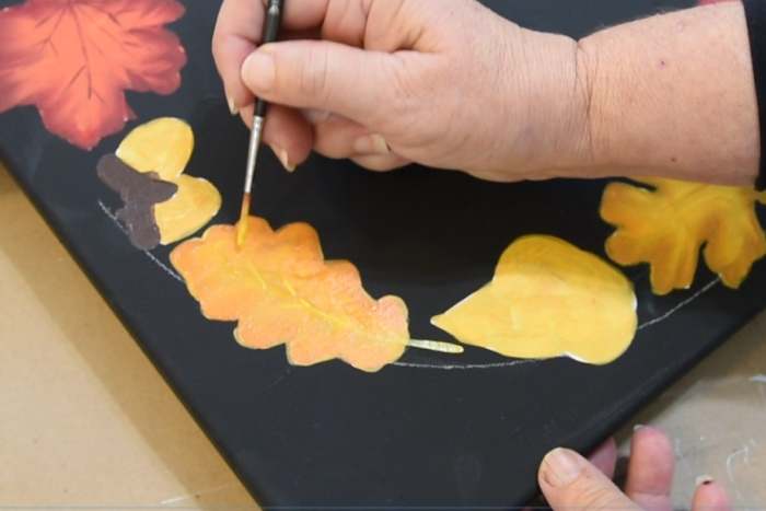 Adding veins to the smaller oak leaves with a liner brush.