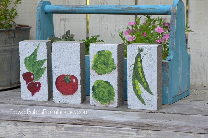 Bricks painted with vegetables as garden markers