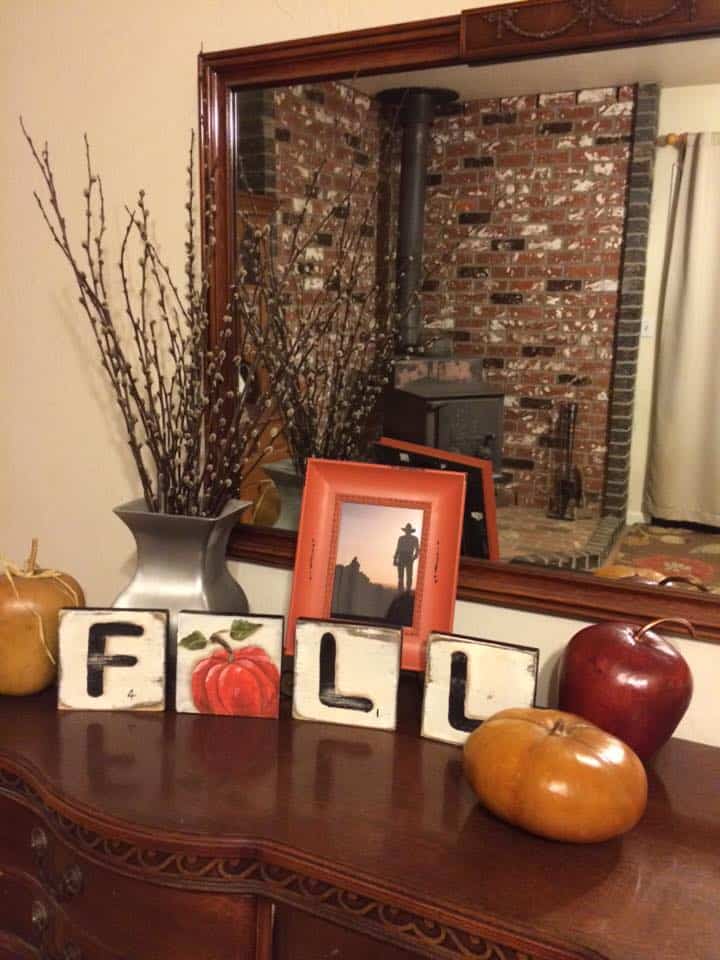 DIY Scrabble tile art on table top with pumpkin, apple, framed photo with a vase of pussy willows