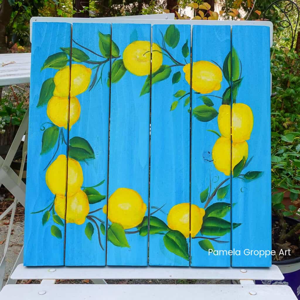 Wreath of Lemons painted on a pallet board, with a beautiful blue background