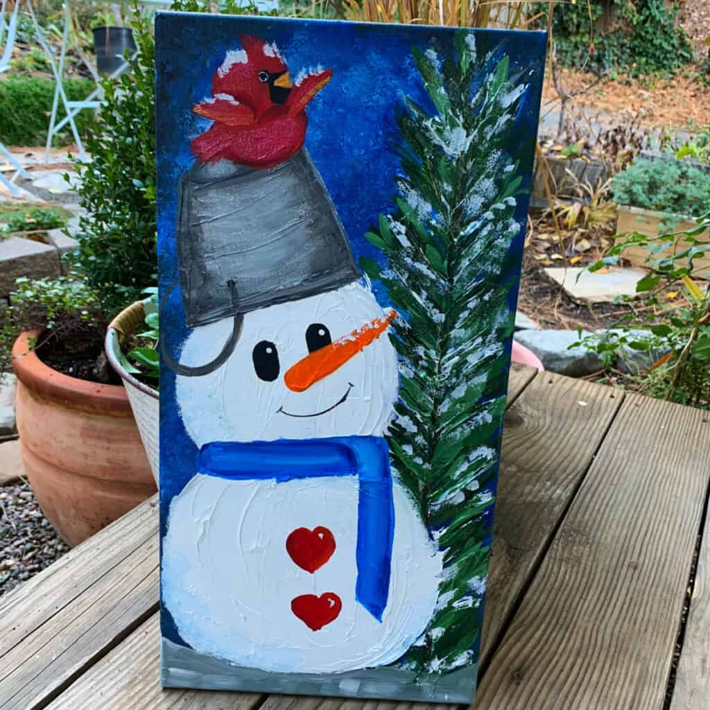 Snowman with a cardinal painted in acrylics with a fir tree