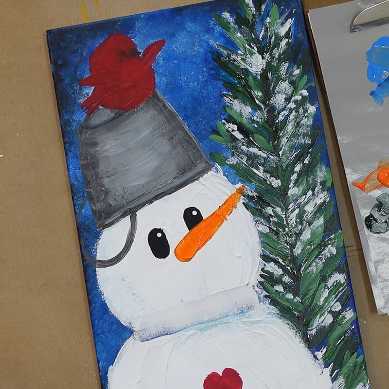 Paint orange on snowman nose and dot eyes