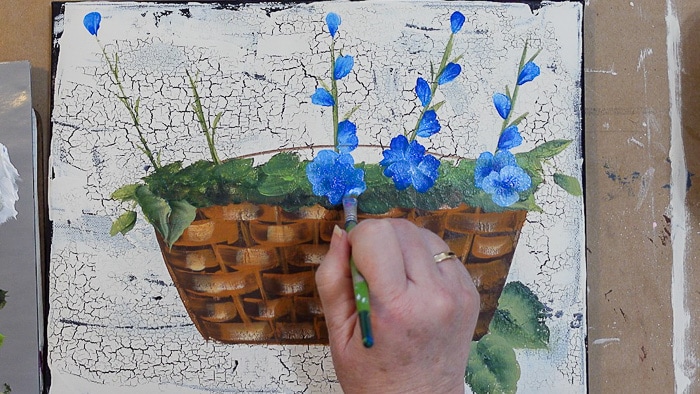 Paint more blue flowers in the basket