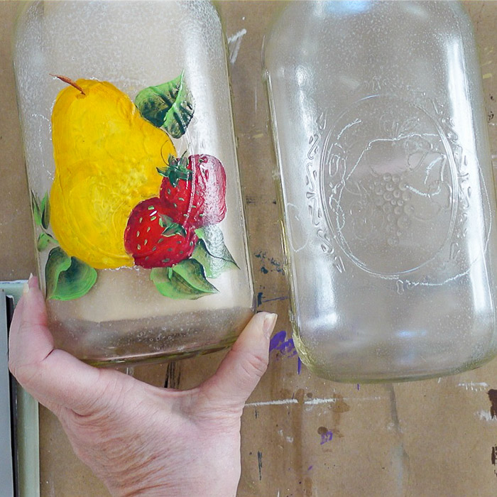 Glass painting pears and strawberries next to an jar with a apple design drawn on ready to paint