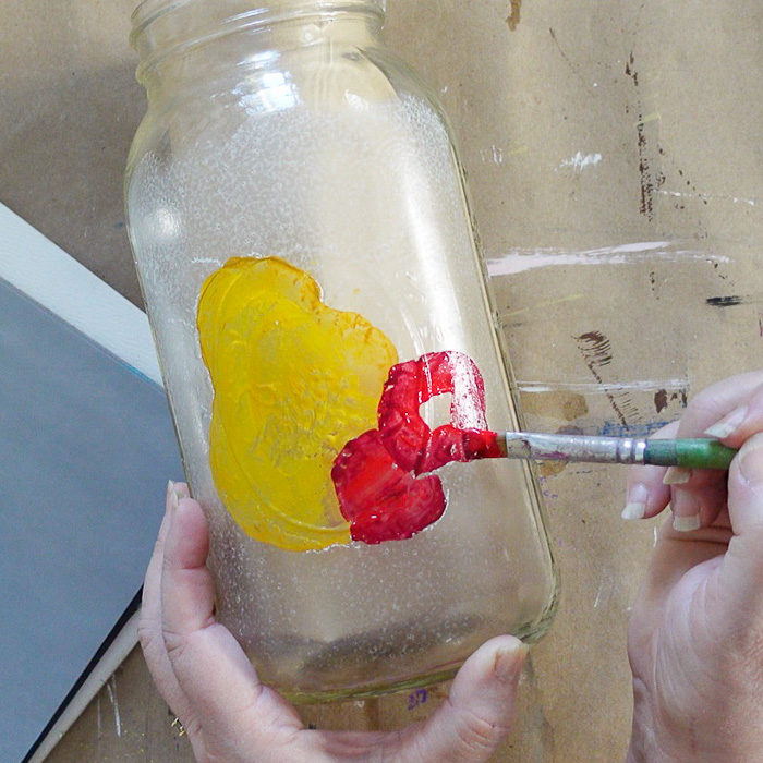 base painting strawberries on glass jar beneath pear