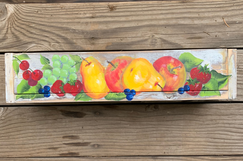 rustic crate with painting of fruit on it