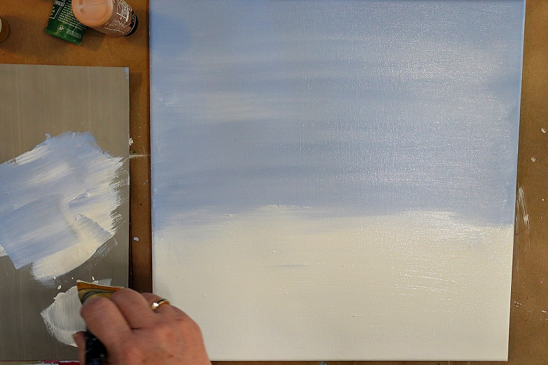 Painting snow below the winter sky with a 2 inch craft brush