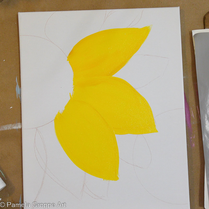 painting sunflower petals with yellow paint on white canvas