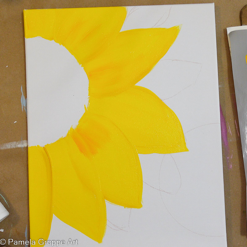 adding orange acrylic paint to yellow sunflower petals to add some shading and interest