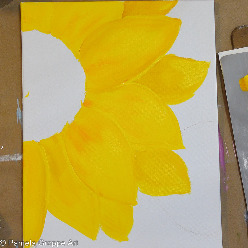 Adding highlights to sunflower petal edges with bright yellow acrylic paint