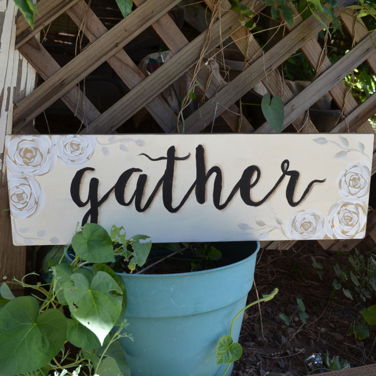 gather sign resting on post with lattice in the background