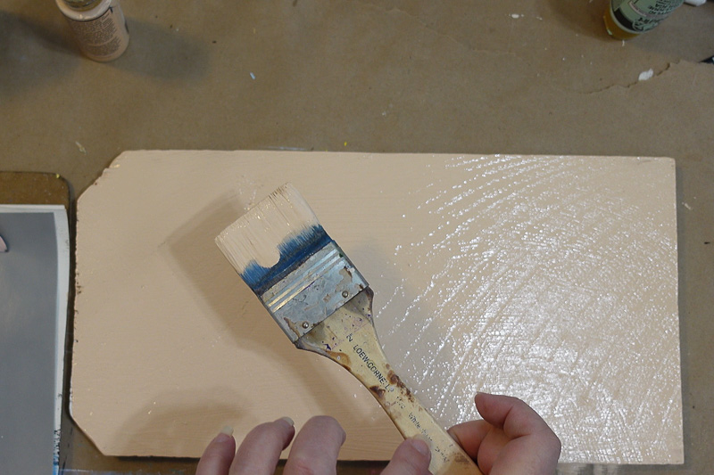 base painting a wood board with paint brush