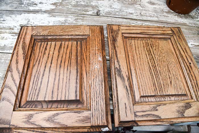cabinet doors laying on a table showing how wood putting was sanded down even with surface