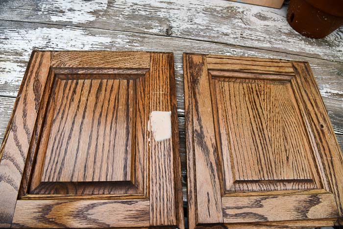 cabinet doors laying on a table with wood putting filled the handle holes