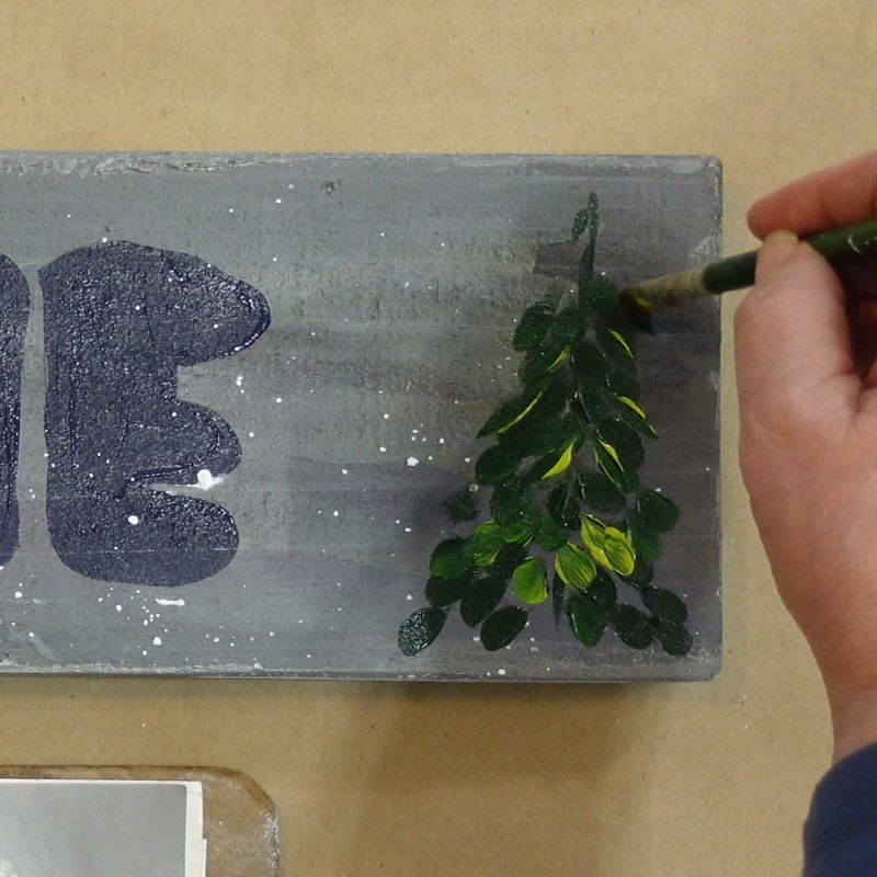 adding light and dark green in layered strokes for painting the evergreen tree