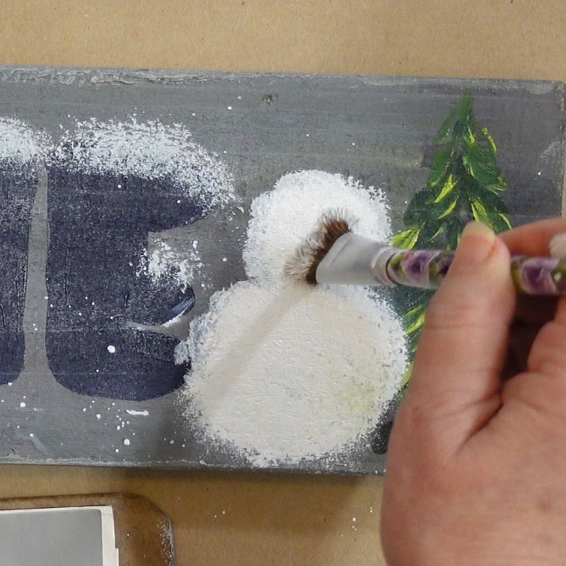 tapping a second coat of white onto the snowman body