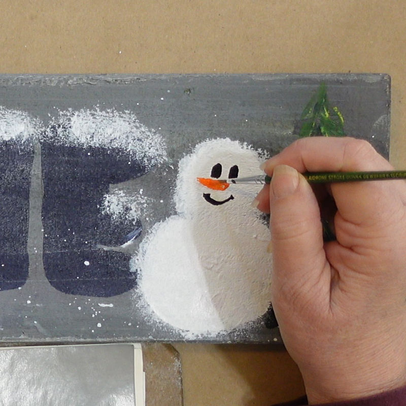 add a black line in an upside down arc for a smile and an orange long triangle for a carrot looking nose