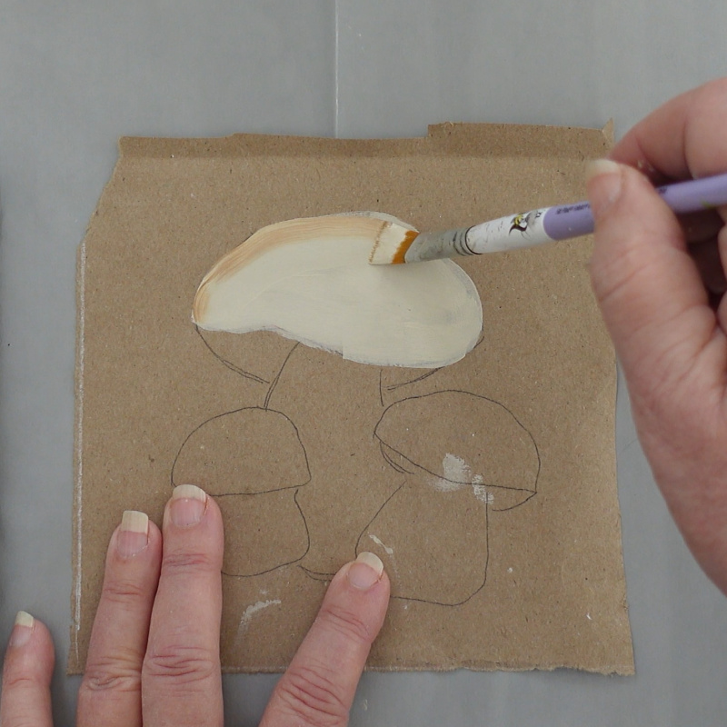mushroom being painted with a linen color they edge is darkened with a medium brown color